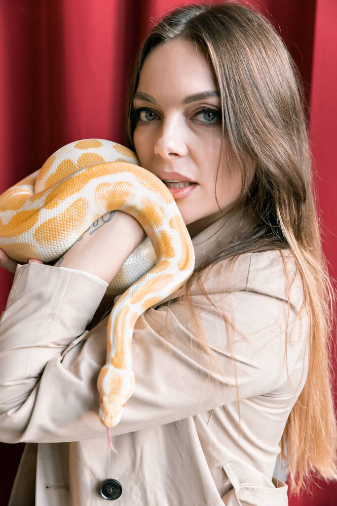 Прекрасна чуттєва жінка з жовтою змією. - Фото, зображення