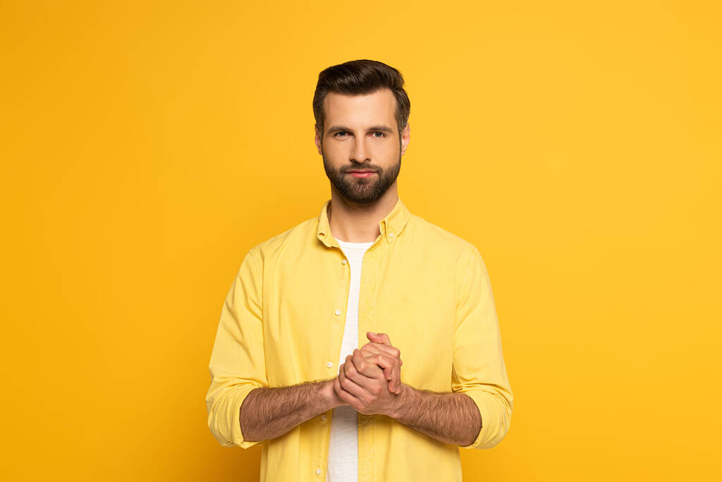 Handsome man showing marriage sign in deaf and dumb language on yellow background - Φωτογραφία, εικόνα
