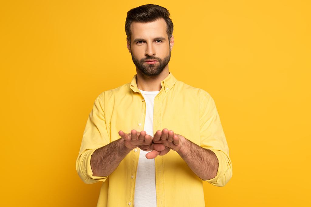 Young man using deaf and dumb language on yellow background - Photo, Image