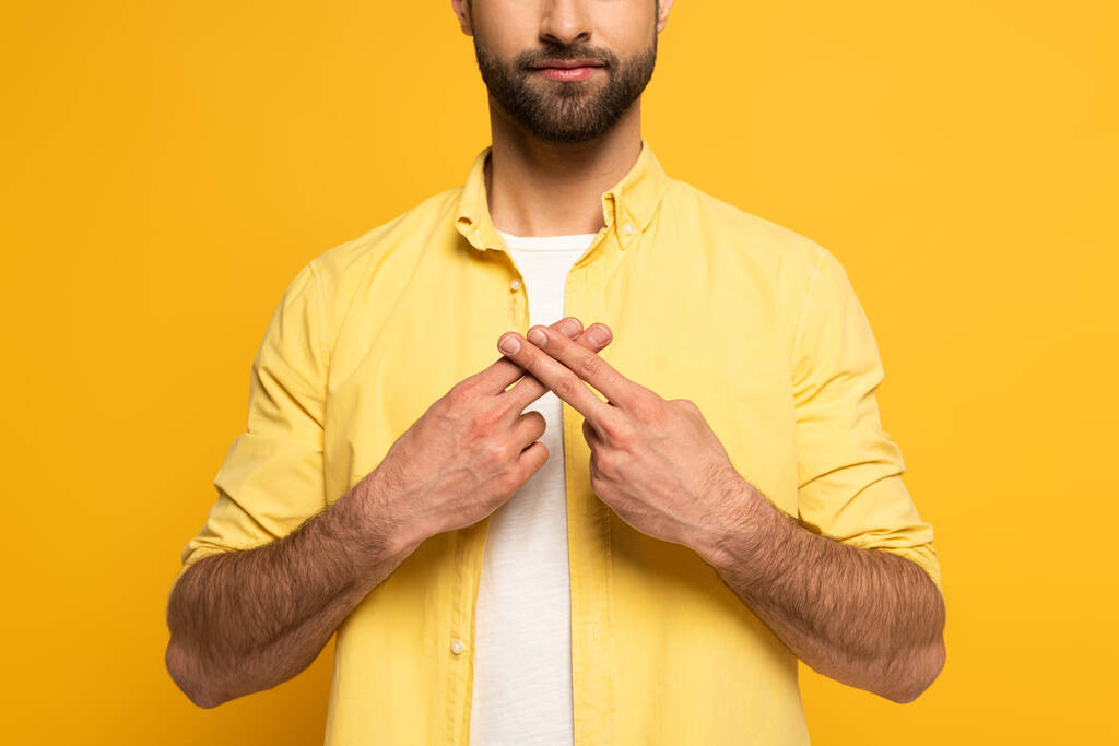 Widok człowieka przy użyciu języka migowego na żółtym tle - Zdjęcie, obraz