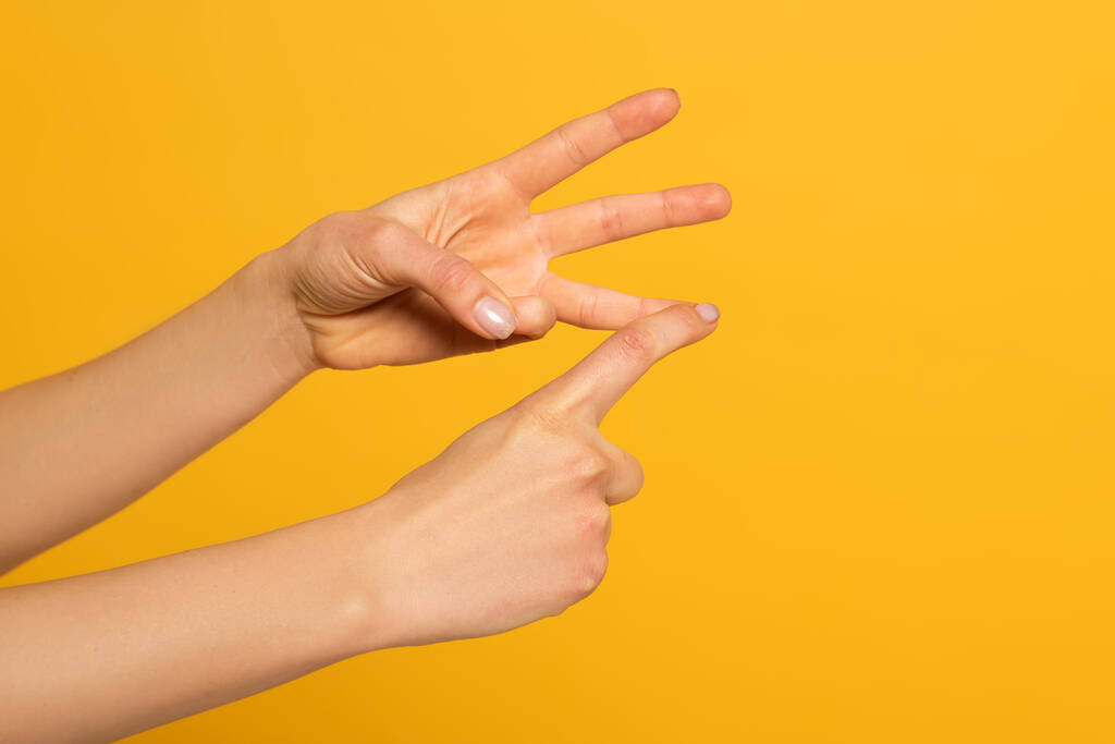 Vista ritagliata della donna gesticolando durante l'utilizzo del linguaggio dei segni isolato sul giallo
  - Foto, immagini