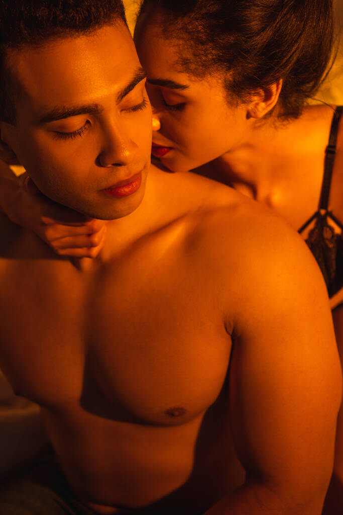 高いです角質ビューのセクシーアフリカ系アメリカ人女性抱擁とキスボーイフレンドでベッドルーム - 写真・画像