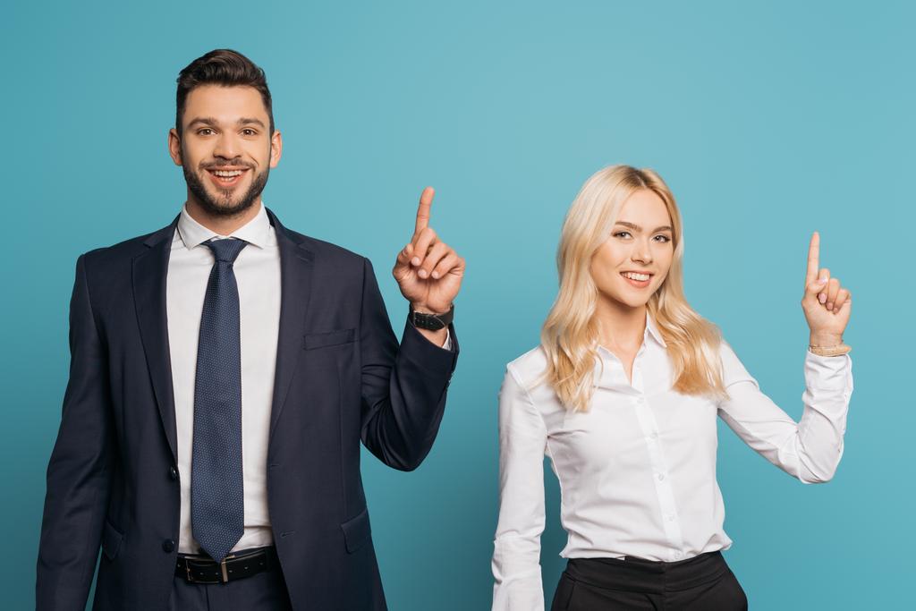 Lächelnder Geschäftsmann und Geschäftsfrau zeigt Ideenschilder, während er in die Kamera auf blauem Hintergrund blickt - Foto, Bild