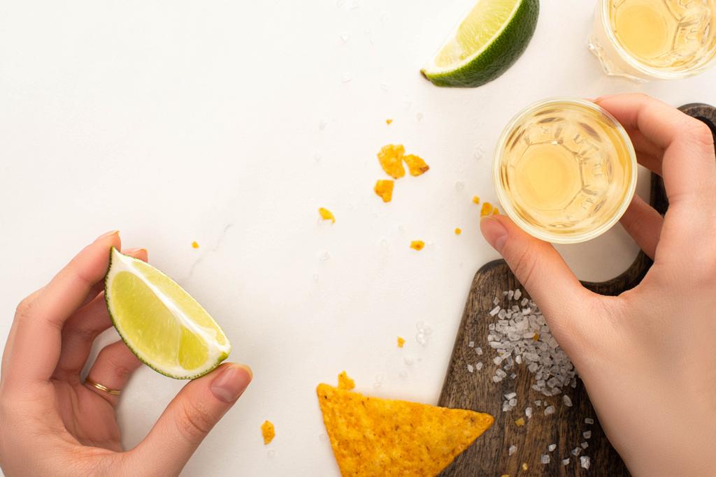 vágott kilátás nő iszik arany tequila lime, só fehér márvány felületen - Fotó, kép