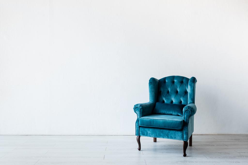 blauer und bequemer Sessel nahe weißer Wand im Wohnzimmer  - Foto, Bild