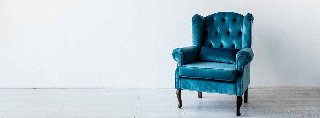 panoramisch gewas van blauwe en comfortabele fauteuil in de buurt van witte muur in woonkamer  - Foto, afbeelding