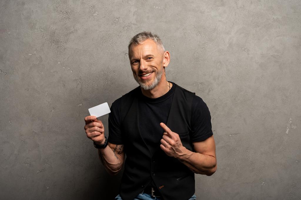 幸せなビジネスマンが指を指差してグレーのカードを  - 写真・画像
