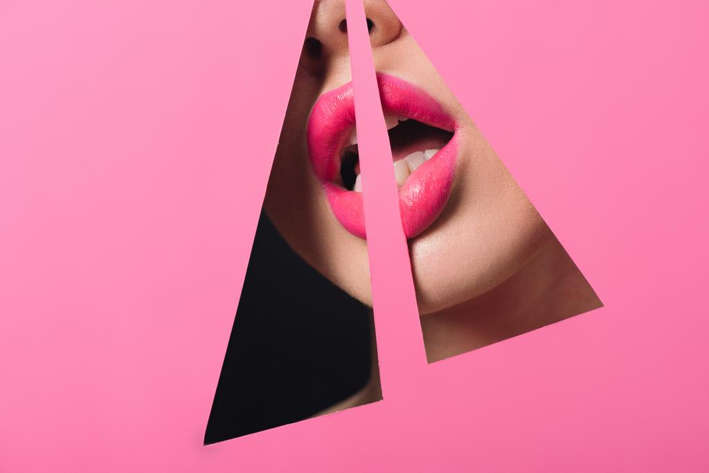 Gewassen gezicht van de vrouw met roze lippen en open mond over driehoekige gaten in papier op zwart - Foto, afbeelding