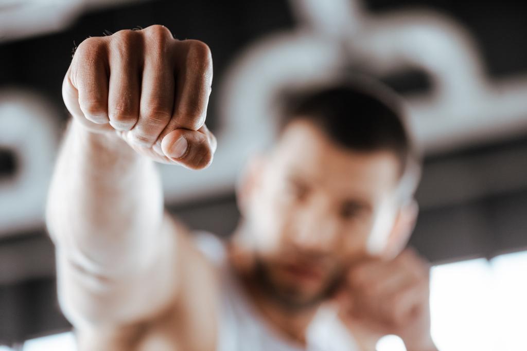 enfoque selectivo del luchador con el puño apretado de entrenamiento en el centro deportivo
  - Foto, imagen