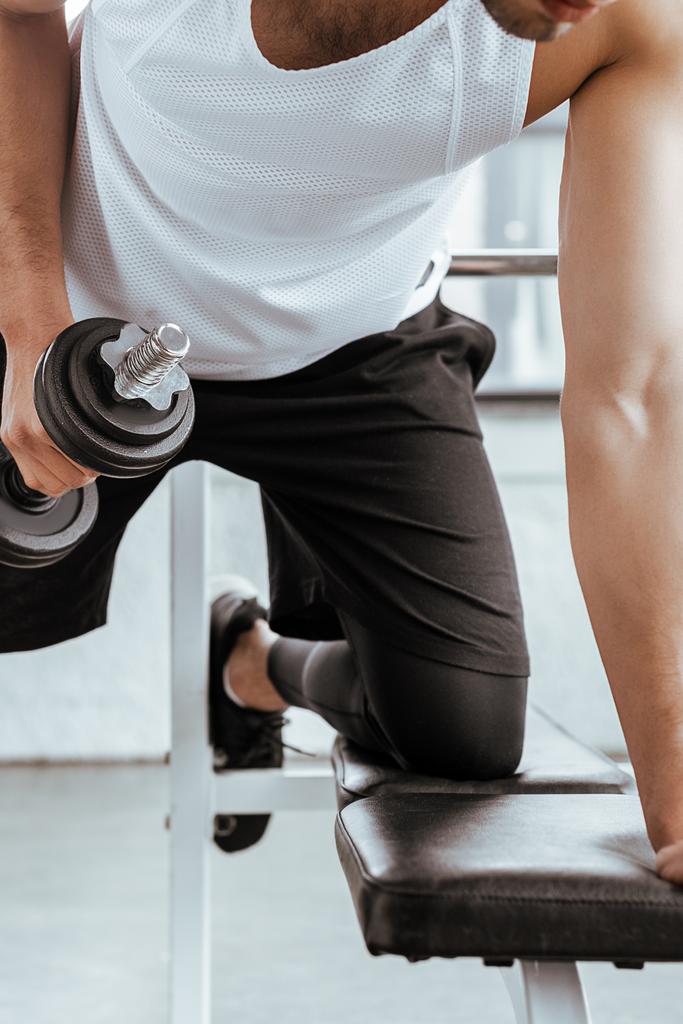 vista recortada del hombre atlético haciendo ejercicio con pesadas mancuernas en el gimnasio
   - Foto, Imagen