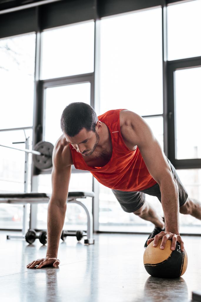 ισχυρός αθλητής κάνει σανίδα άσκηση με μπάλα  - Φωτογραφία, εικόνα