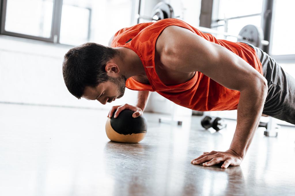 αθλητικός αθλητής κάνει σανίδα άσκηση με μπάλα  - Φωτογραφία, εικόνα