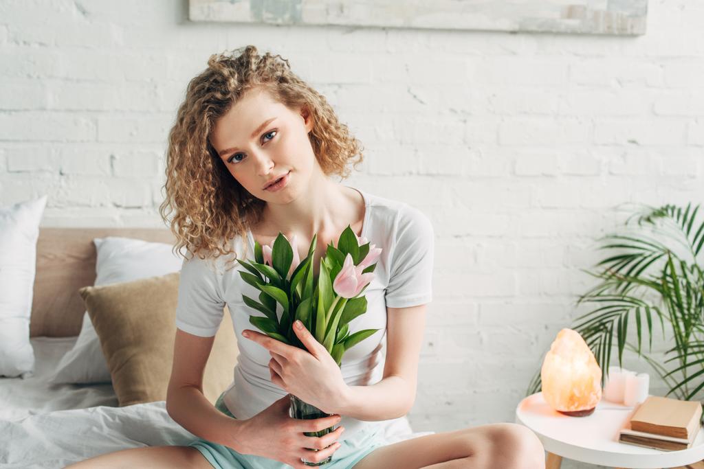 curly girl holding tulips in bedroom with Himalayan salt lamp - Photo, Image