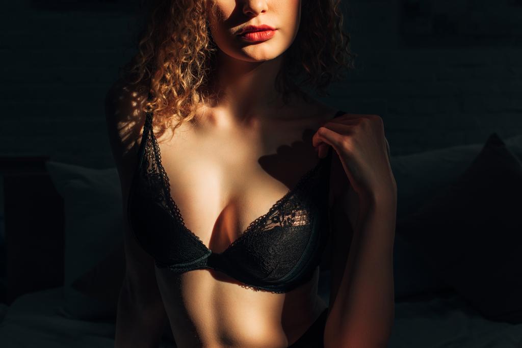 rajattu näkymä seksikäs kihara tyttö musta rintaliivit sängyssä auringonvalossa
 - Valokuva, kuva