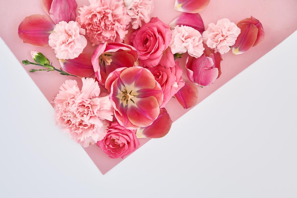 κορυφαία άποψη των τριαντάφυλλων, τουλίπες και γαρύφαλλα σε ροζ και λευκό φόντο - Φωτογραφία, εικόνα