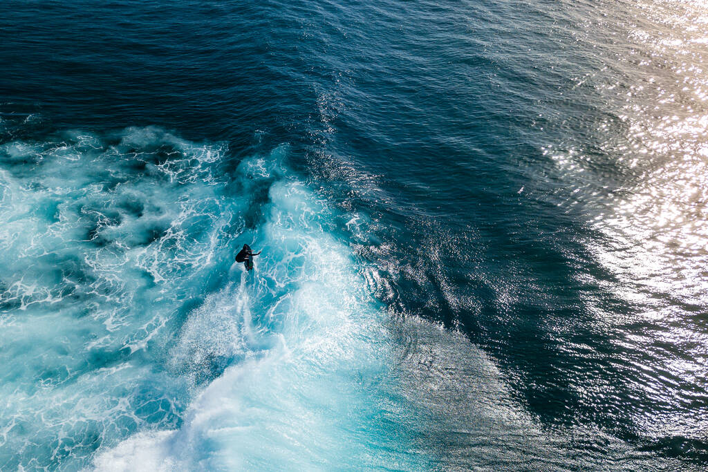 Joven surfista con traje de neopreno en grandes olas oceánicas en Tenerife, Islas Canarias. Valiente adolescente haciendo trucos en el mar agitado
 - Foto, imagen