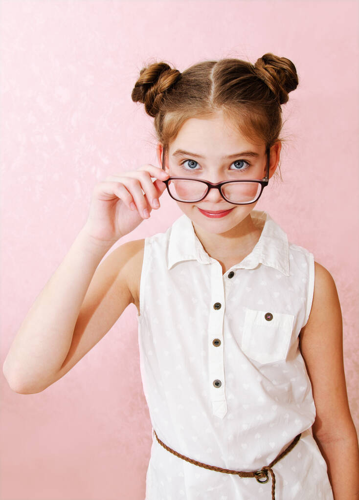 Lindo niño niña preadolescente en gafas educación, escuela y concepto de visión aislado en un rosa
 - Foto, imagen