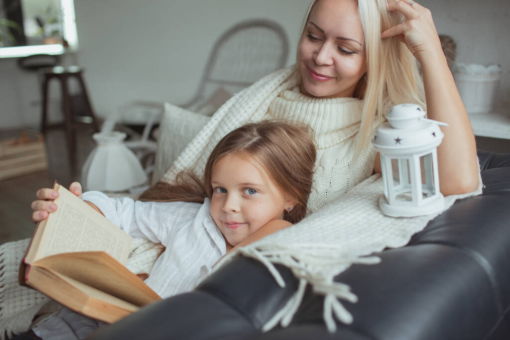 Сім'я в період самоізоляції читає книги вдома на дивані. Як зберегти себе зайнятим під час карантину, не виходячи з дому
 - Фото, зображення