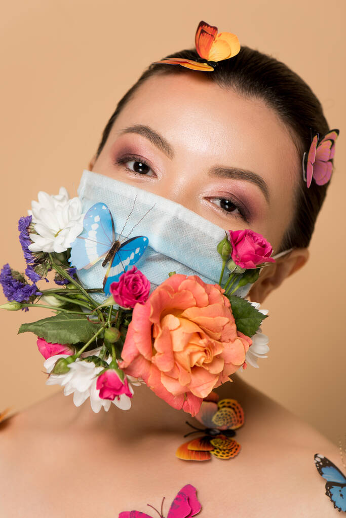 attractive asian woman in latex gloves and floral face mask with butterflies on beige - Photo, Image