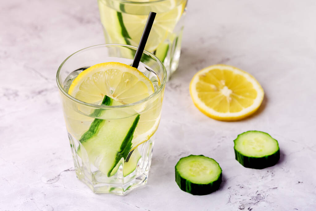 Gläser gesundes Detox-Wasser mit Zitrone und Gurken Diät-Trinkhalm waagerecht darüber - Foto, Bild