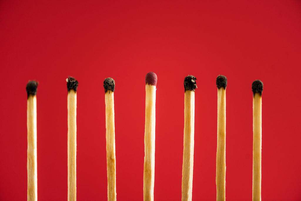 Unburned match among another isolated on red - Photo, Image