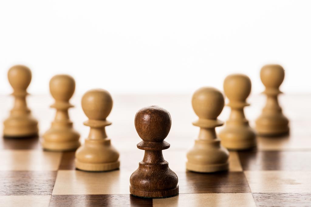 白に隔離されたチェス盤の中で、茶色の駒の選択的焦点 - 写真・画像