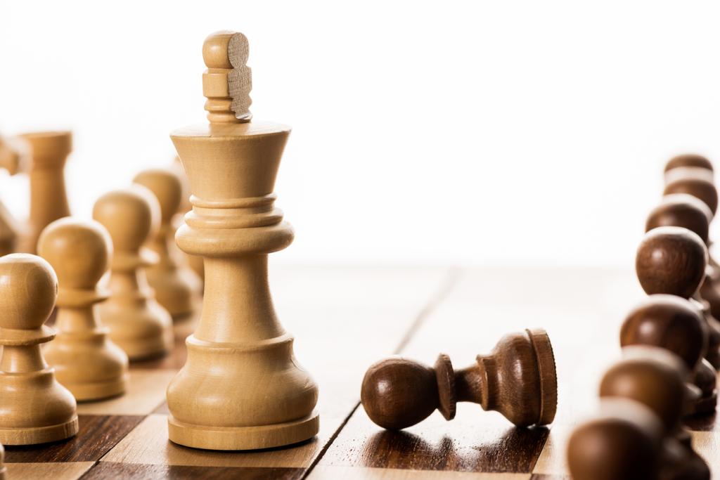 Selective focus of king with pawns on chessboard isolated on white - Photo, Image