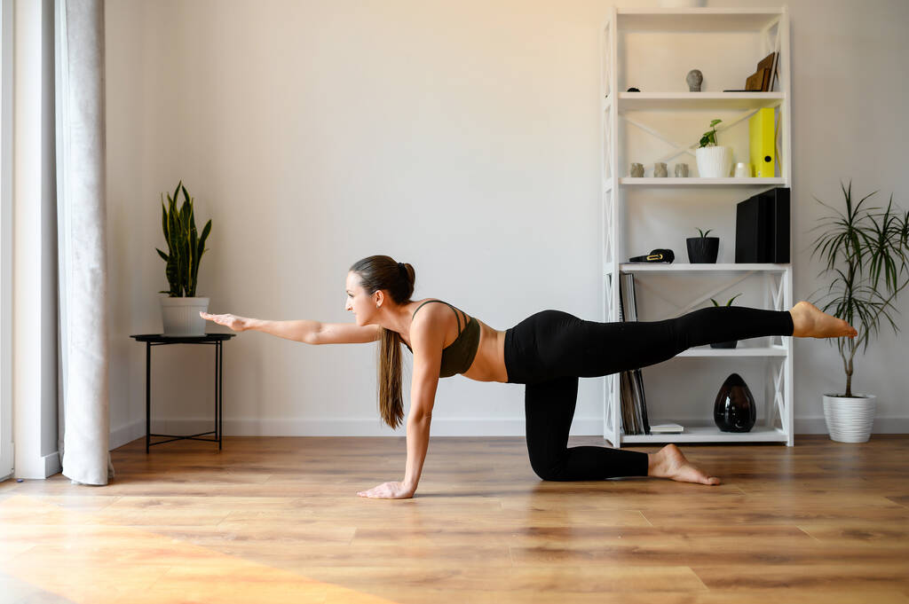 Giovane donna positiva sta praticando yoga a casa
 - Foto, immagini