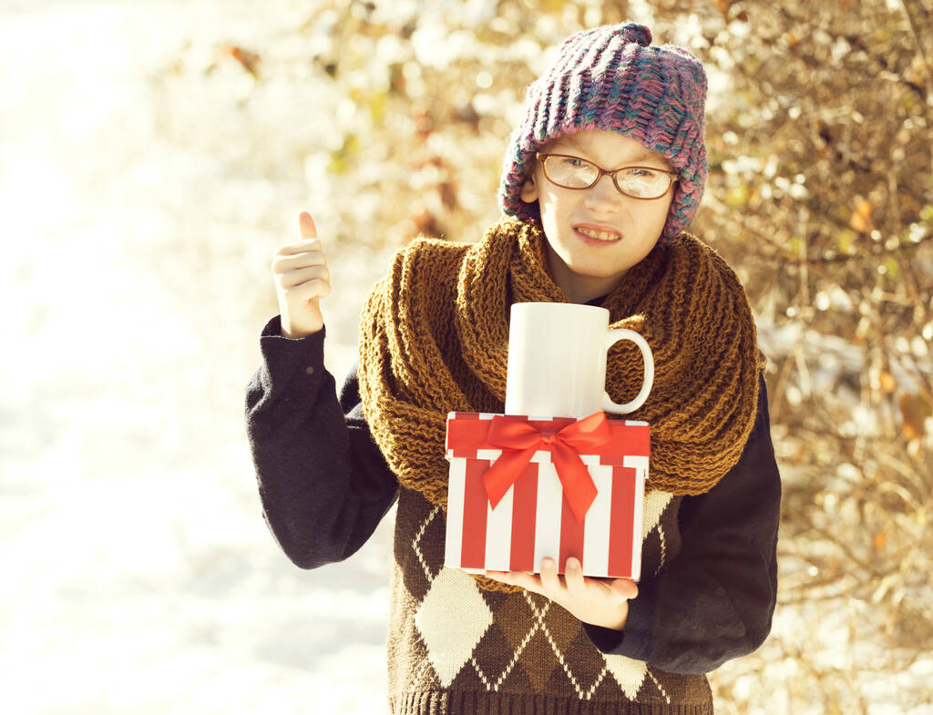 маленький хлопчик з подарунком і чашкою взимку на відкритому повітрі
 - Фото, зображення
