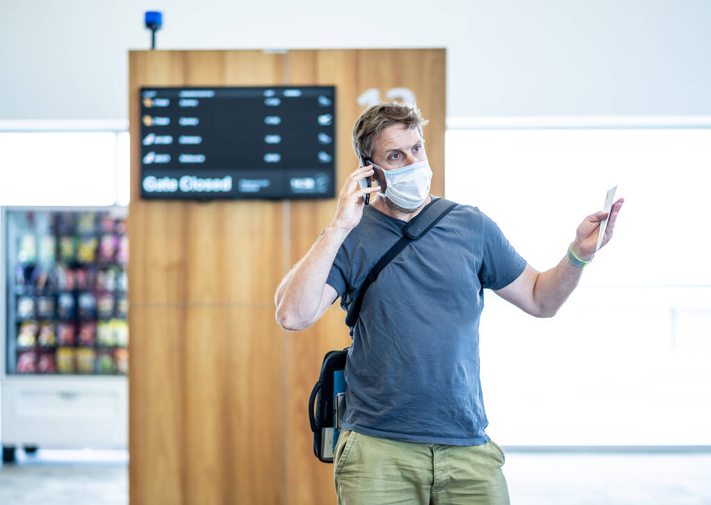 COVID-19 zamyka światowe granice Podróżnik z maską na twarzy, który utknął w terminalu lotniskowym po odmowie wjazdu do innych krajów. Pasażer pozostawiony na lotnisku w podróży powrotnej do kraju pochodzenia. - Zdjęcie, obraz