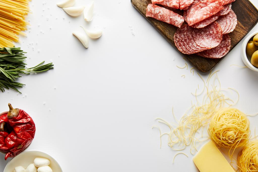 Vista superior de bandeja de carne, pasta e ingredientes sobre fondo blanco
  - Foto, Imagen