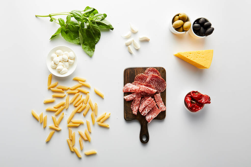 Vista superior de pasta, bandeja de carne, queso e ingredientes en blanco
  - Foto, imagen