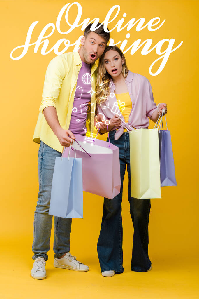 hermosa pareja sorprendida sosteniendo bolsas de compras en amarillo, ilustración de compras en línea
 - Foto, imagen