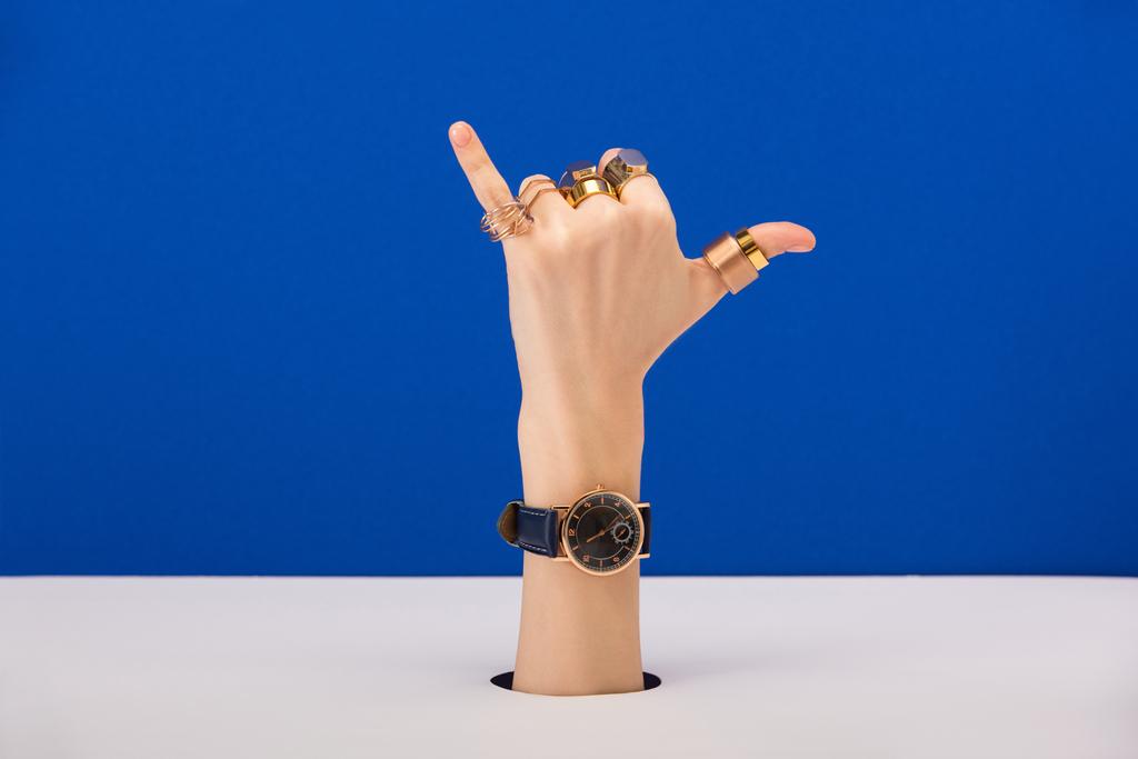 recortado vista de la mujer con reloj de pulsera y anillos que muestran llámame gesto aislado en azul
 - Foto, imagen