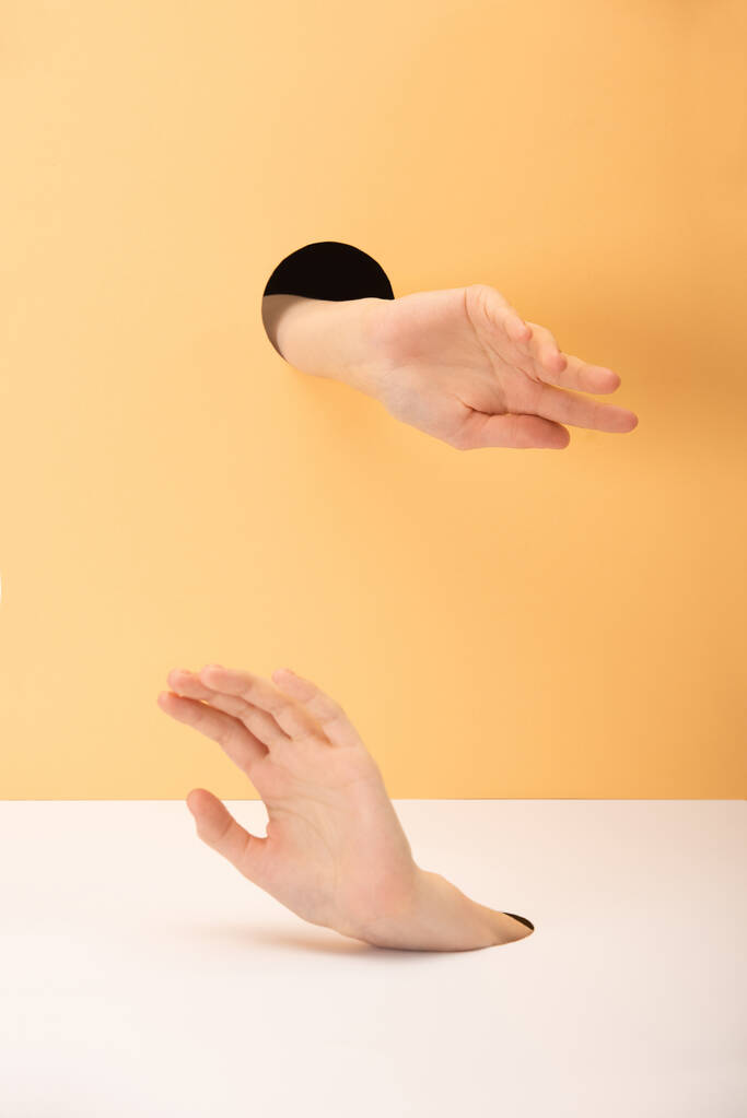 vista cortada da mulher gesticulando com as mãos em branco e laranja
 - Foto, Imagem