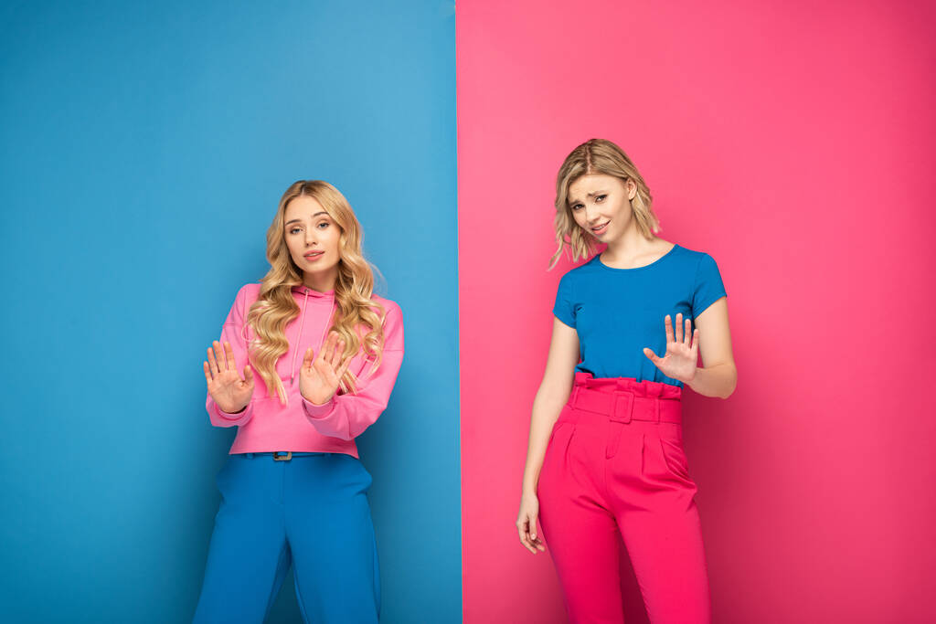 Красиві блондинки показують стоп жест на рожевому і синьому фоні
 - Фото, зображення