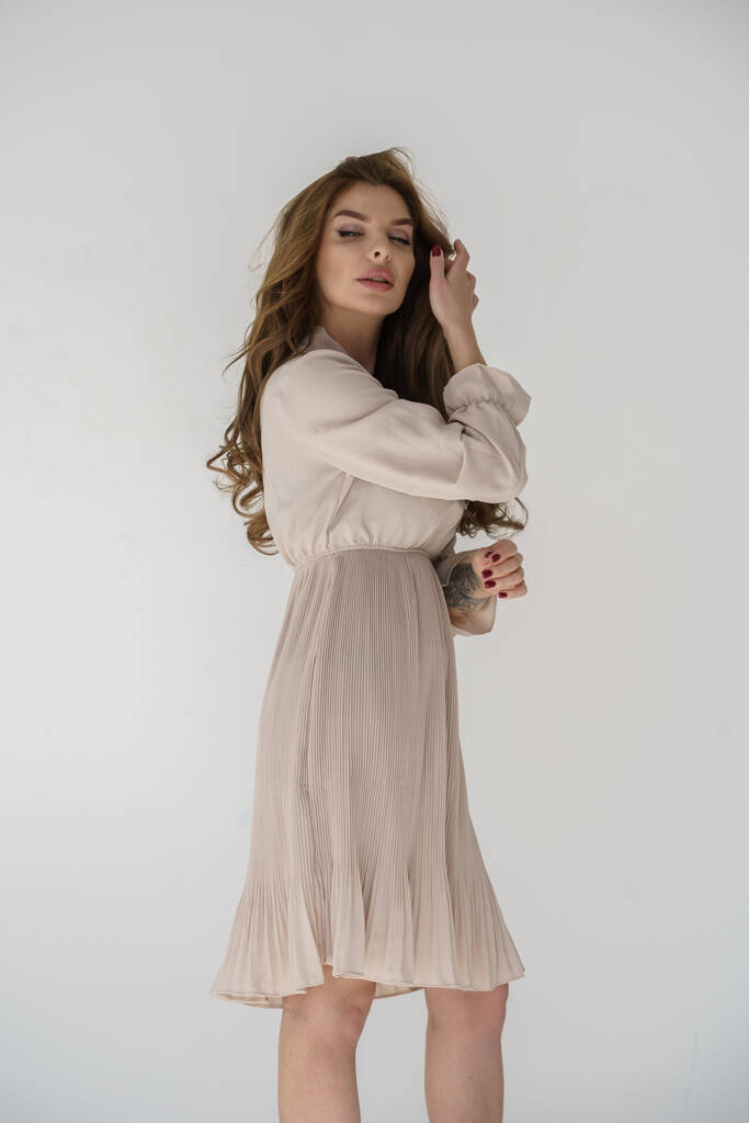 Hermosa chica sexy rubia en un vestido posando sobre un fondo blanco
 - Foto, Imagen