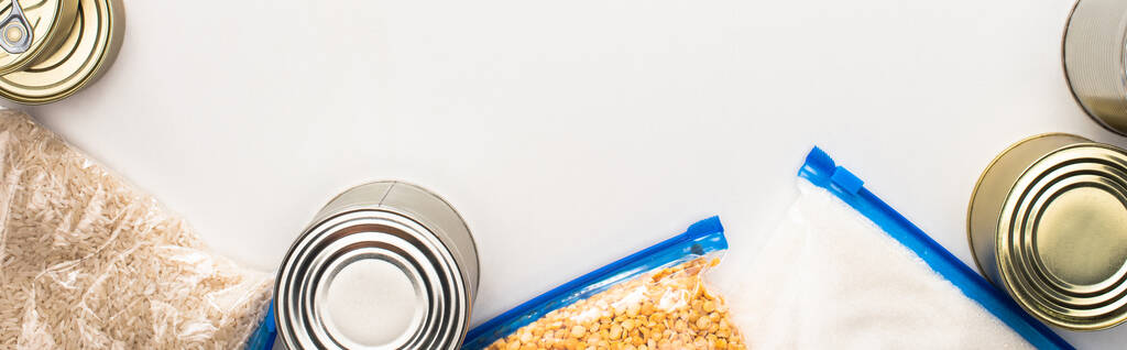 vista superior de latas y grañones en bolsas con cremallera sobre fondo blanco, concepto de donación de alimentos
 - Foto, imagen