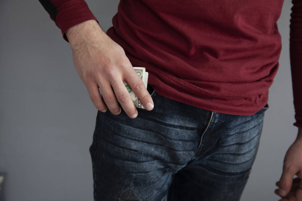 férfi kéz tartja a pénzt a zsebében - Fotó, kép