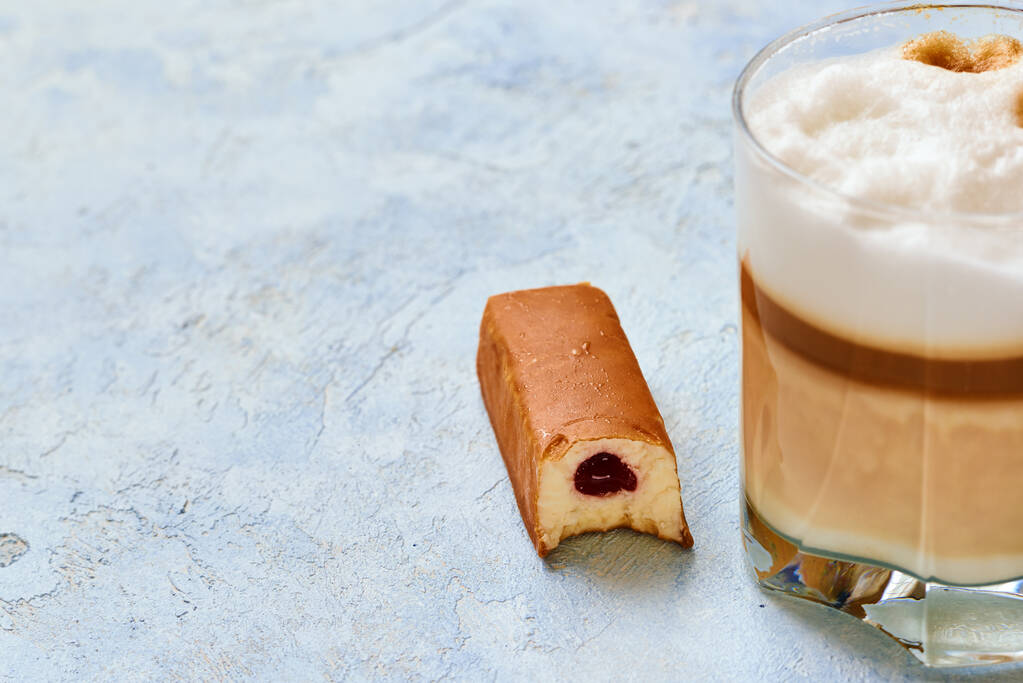 chocolate cheese and cappuccino in a glass cup prepared in a home coffee machine on a blue background. - Photo, Image
