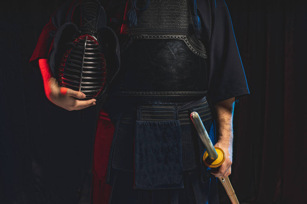 cropped kendo αρσενικό κρατώντας κράνος και σπαθί shinai στα χέρια - Φωτογραφία, εικόνα