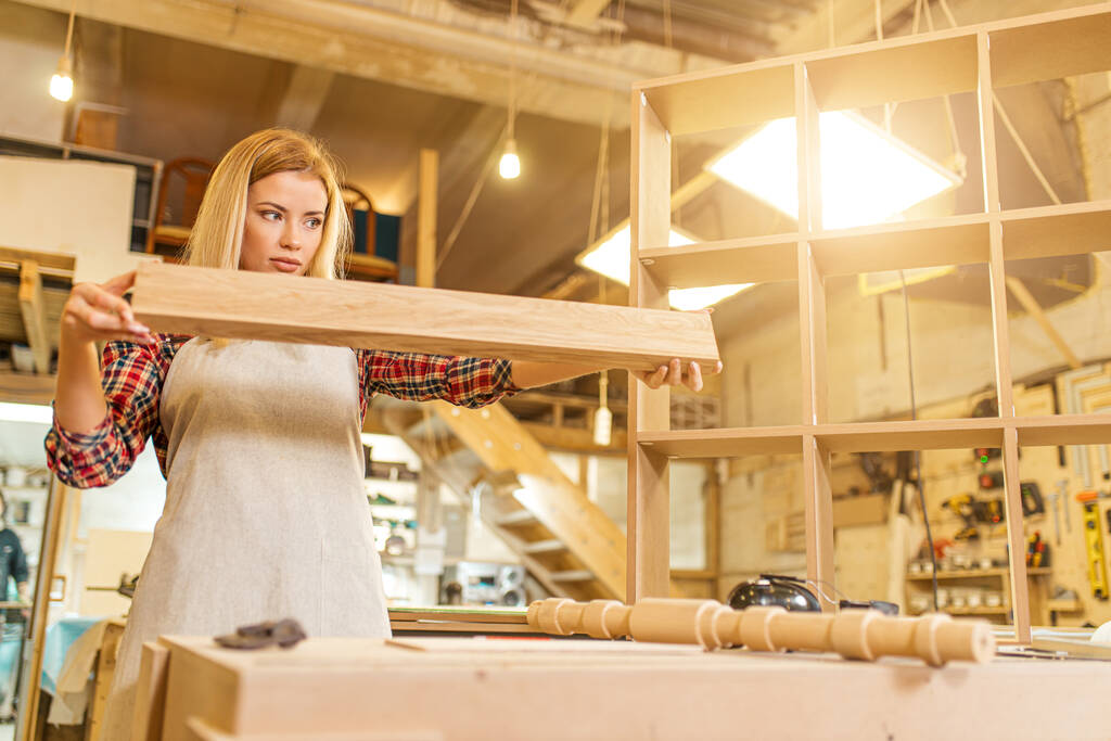 lavoratrice del legno donna che controlla pezzo di legno
 - Foto, immagini