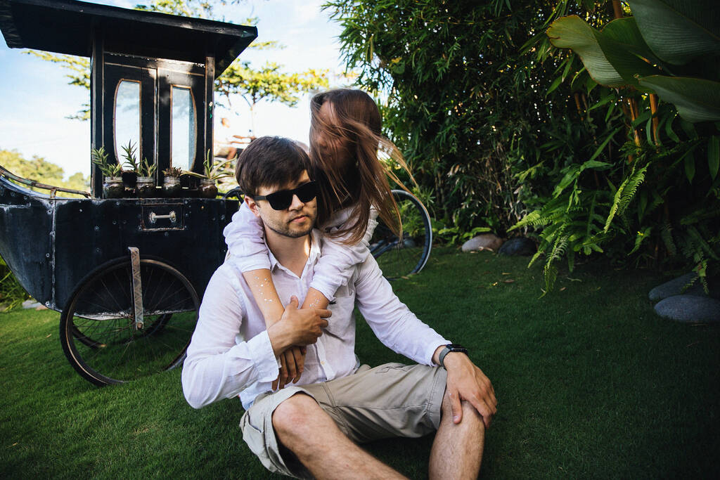 casal em abraços de amor e se diverte em um passeio romântico na ilha exótica de Bali, na Indonésia, perto de palmeiras
 - Foto, Imagem
