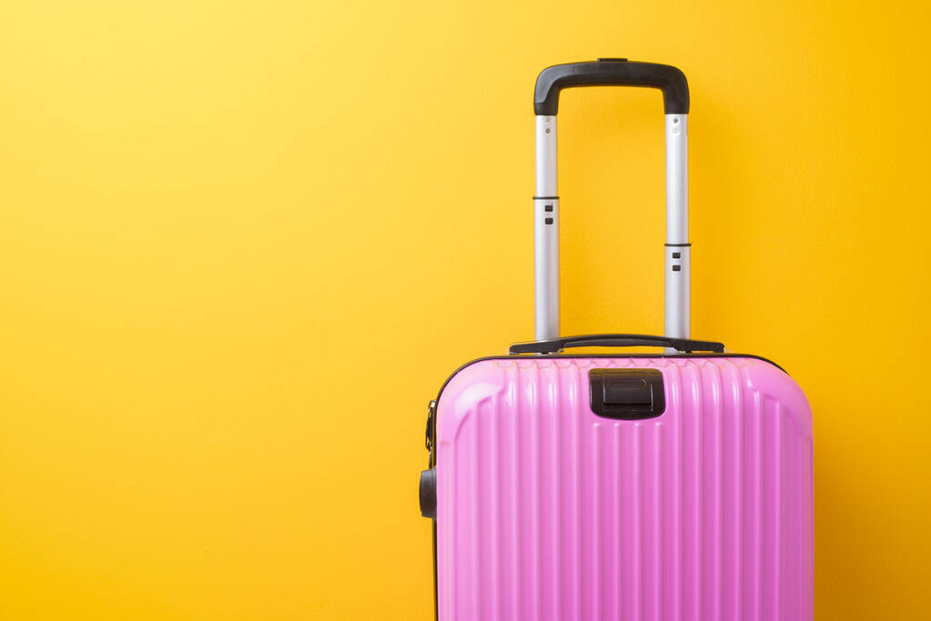 Розовый багаж на желтом фоне, концепция путешествия
  - Фото, изображение