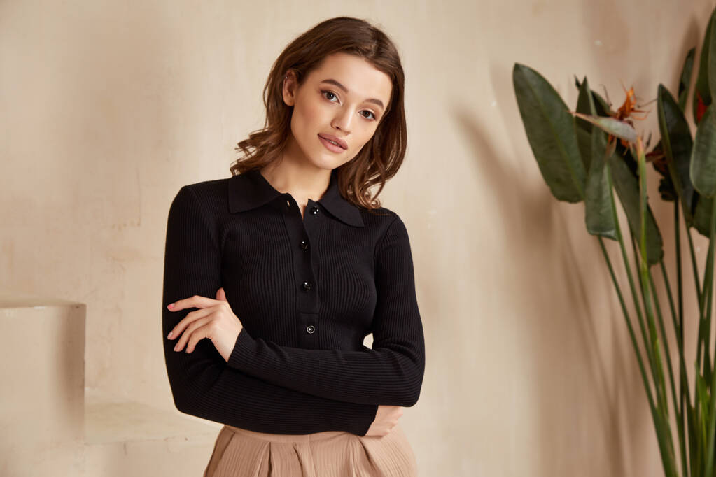 Beautiful brunette woman natural make up wear fashion clothes casual dress code office style black blouse and beige pants suit for romantic date business meeting accessory interior stairs flowerpot. - Photo, Image