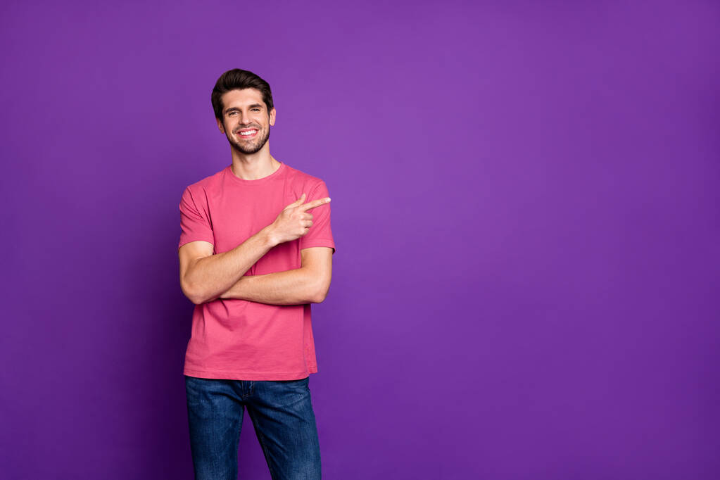 Portrait de positif gai gars promoteur point index copyspace démontrer annonces promotion recommander de choisir porter tenue de bonne apparence isolé sur fond de couleur violet vif
 - Photo, image