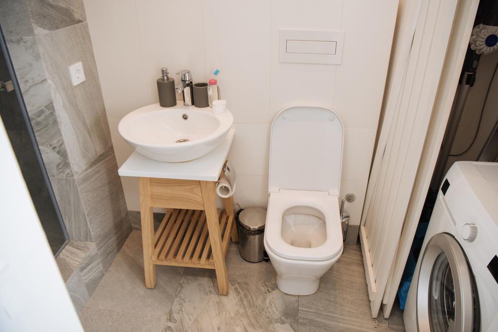 μοντέρνο μπάνιο με τουαλέτα, νιπτήρα και πλυντήριο ρούχων  - Φωτογραφία, εικόνα