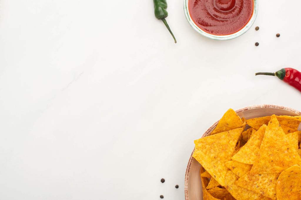 vista dall'alto dei nachos di mais con peperoncino, ketchup su sfondo bianco
 - Foto, immagini
