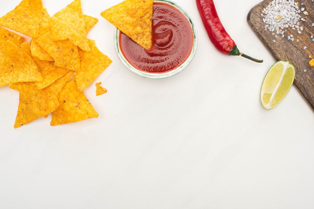 vista dall'alto di nachos di mais con lime, peperoncino, ketchup su sfondo bianco
 - Foto, immagini