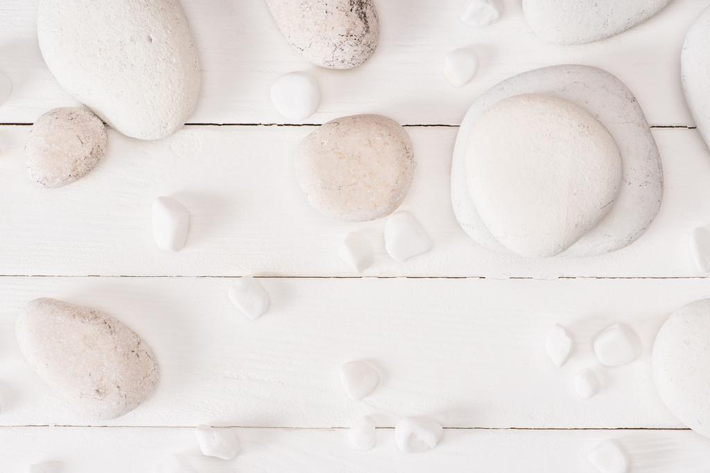 Top view of sea stones on white wooden background - Photo, Image